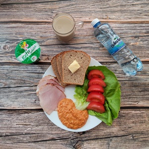Zdjęcie przedstawia dietę z ograniczeniem łatwoprzyswajalnych węglowodanów 
Chleb Graham Masło extra Pomidor Kefir Szynka krucha z pieca wieprzowa, parzona Woda mineralna Sałata zielona Hummus paprykowy